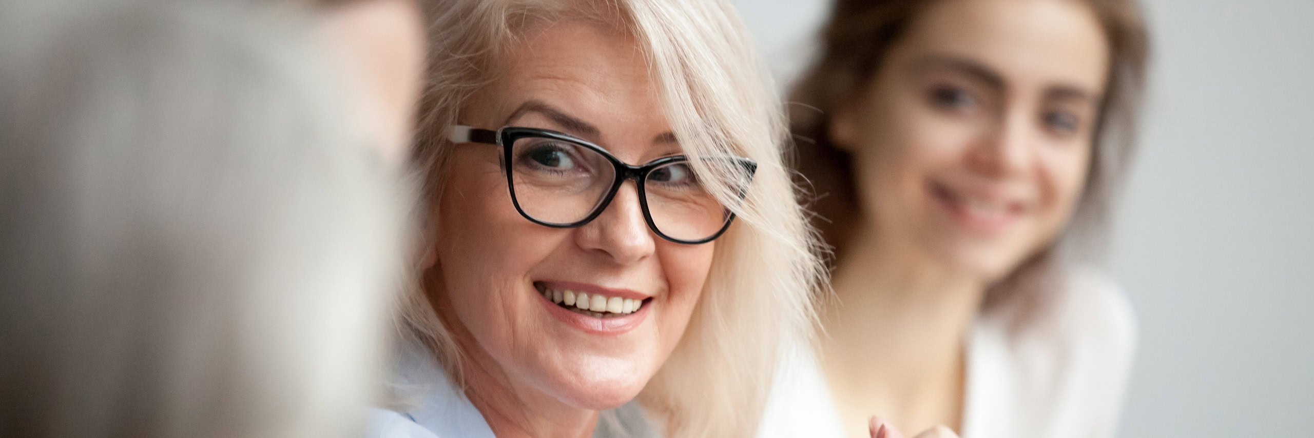 Zwei Frauen schauen zu einer anderen Person